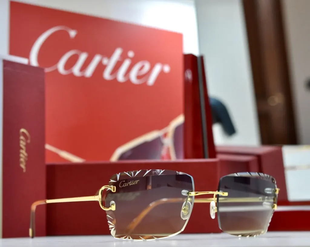 Luxury Cartier C Décor sunglasses featuring geometric lens engravings and gold-finish temples with branded display case